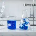 Deux flacons contenant un liquide bleu dans un laboratoire